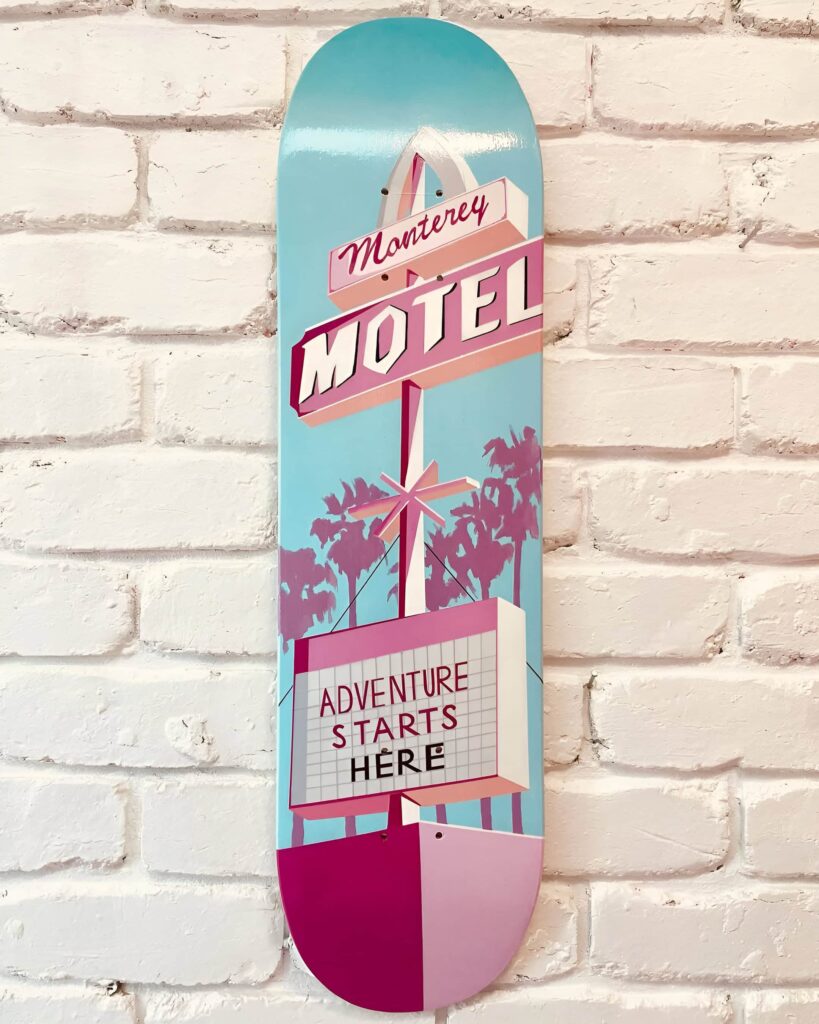 Skateboard wall art in a girl's bedroom features a retro Barbie-inspired motel theme with pastel colors and nostalgic charm.