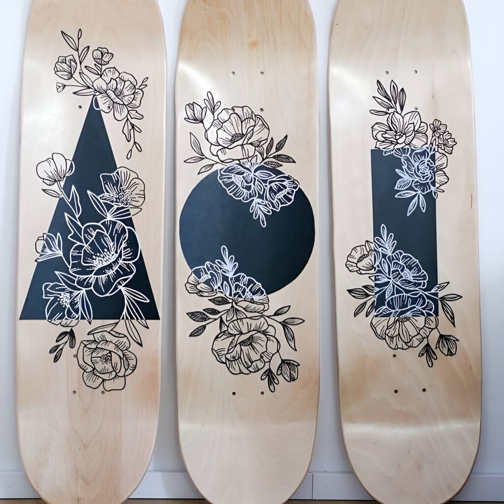 Skateboard wall art black and white design featuring floral illustrations layered over geometric shapes on natural wood decks, ideal for a stylish girls bedroom.