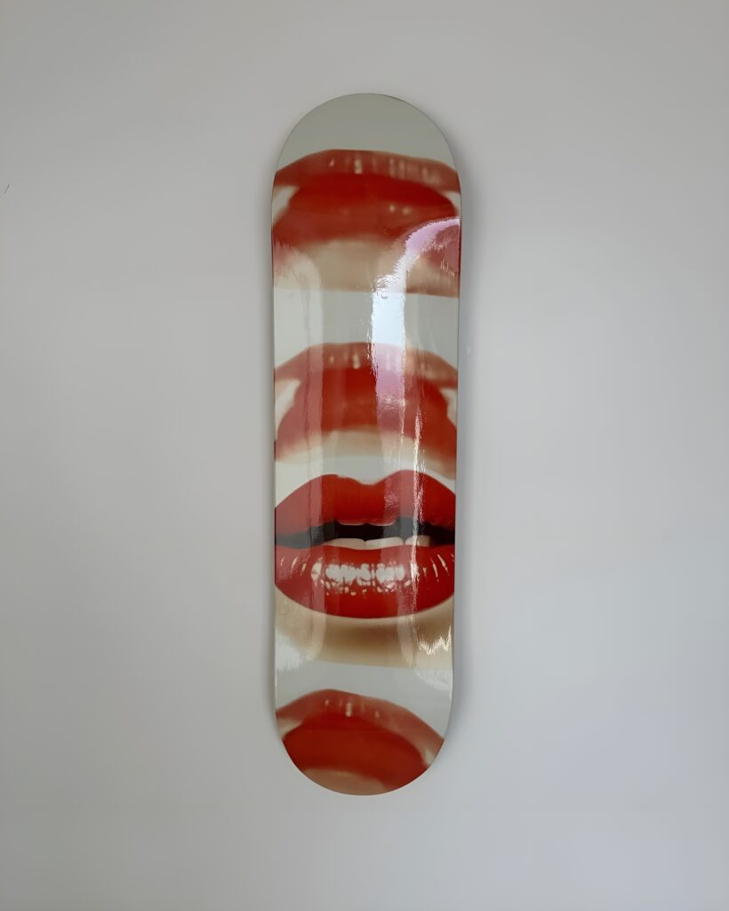 Glossy skateboard deck featuring repeated close-up images of red lips, perfect for bold and edgy Skateboard Wall Art manic cherry style in a girl's bedroom.