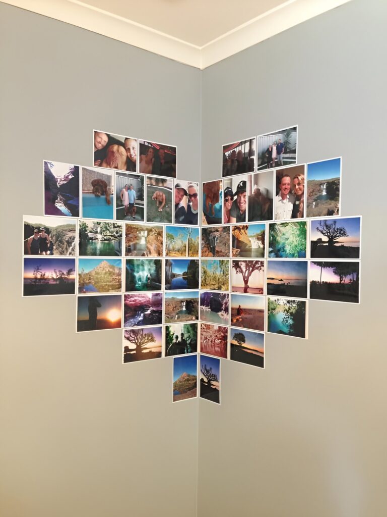 Heart shaped wall collage created with square photos arranged across two intersecting walls, featuring a mix of travel, nature, and personal memories.