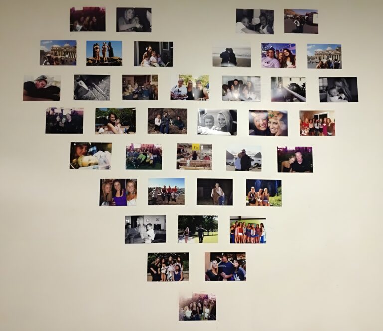 Heart shaped wall collage made from printed photos arranged directly on a blank wall to form a creative and personal display of memories.