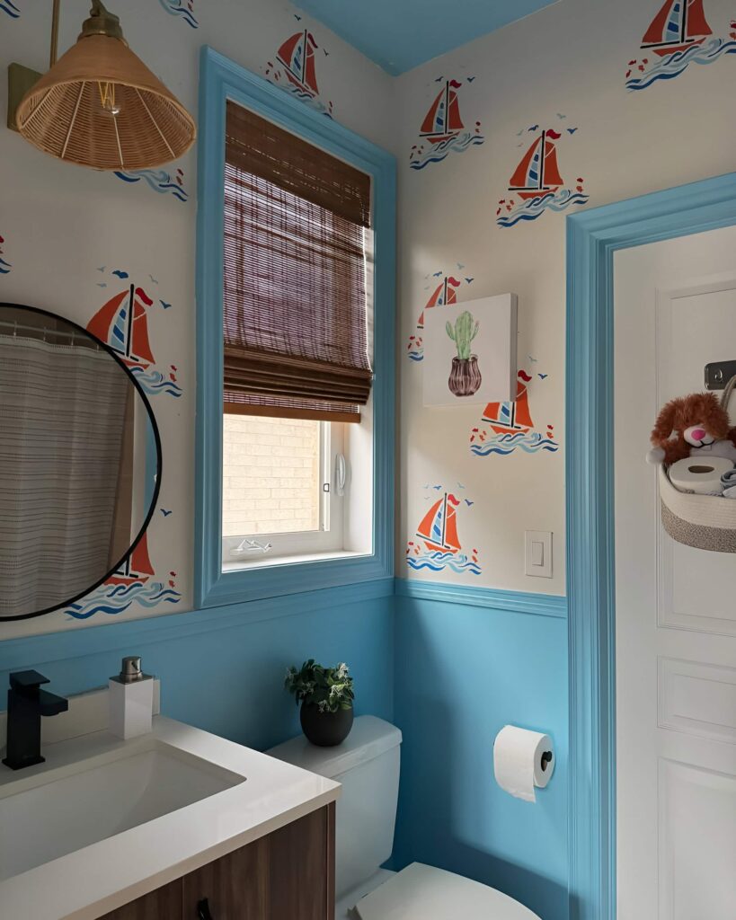 Playful bathroom design ideas for boys with nautical-themed wallpaper, blue accents, and a modern vanity with dark wood and sleek black fixtures.