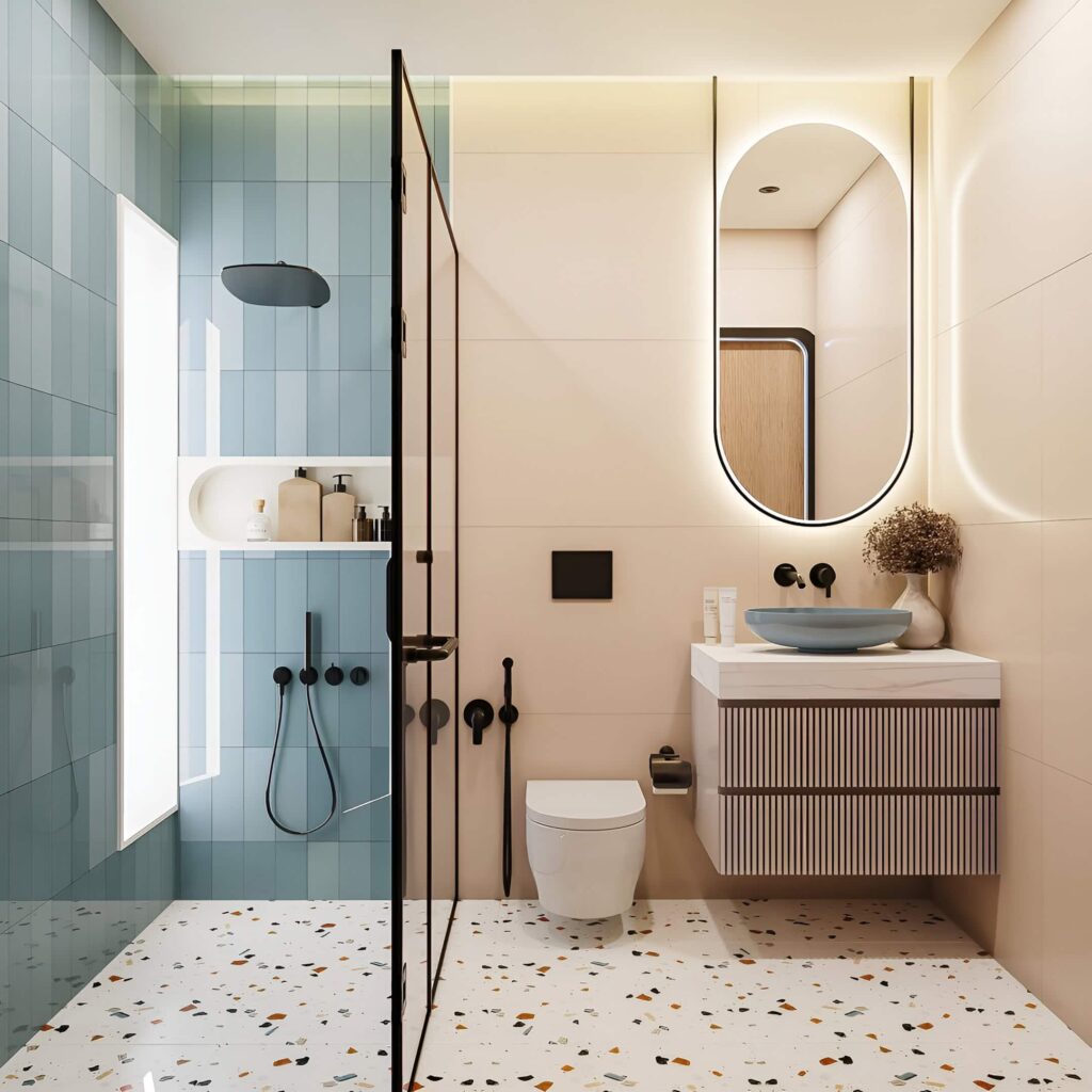 Modern boys' bathroom design featuring terrazzo flooring, pastel blue tiles, matte black fixtures, and a backlit oval mirror.